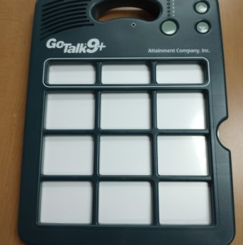 Dark green AAC device with nine big buttons and three smaller buttons up top