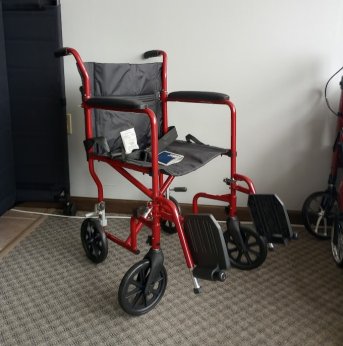 Red transport chair with foot rests